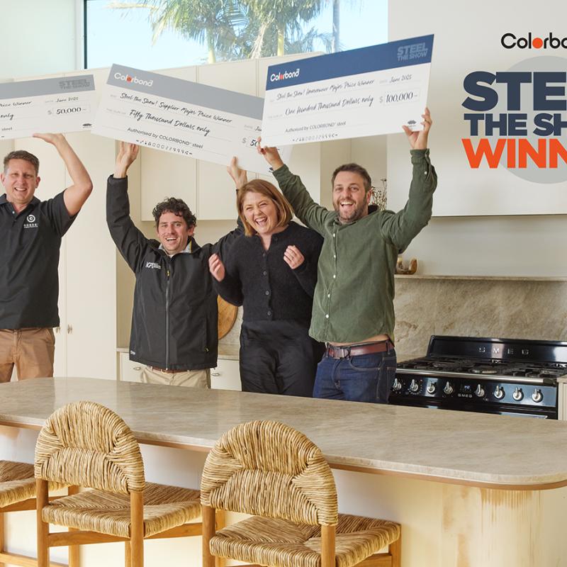 Steel The Show - Grand Prize Winners - Melinda and her building suppliers standing in a kitchen excitedly holding up their prize winning checks