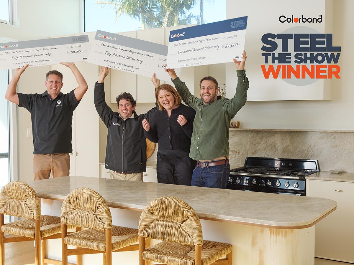 Steel The Show - Grand Prize Winners - Melinda and her building suppliers standing in a kitchen excitedly holding up their prize winning checks